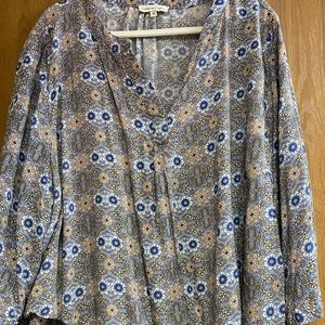 Pattern shirt with a v neck and cross layering bottom detail. 3/4 sleeves